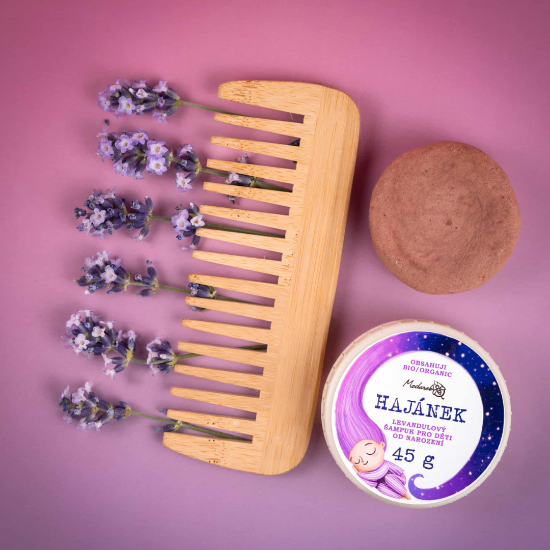Product photo of “Hajánek” lavender kids shampoo bar by Medarek – round solid shampoo and 45 g illustrated tin with a wooden comb and fresh lavender sprigs on a purple background.